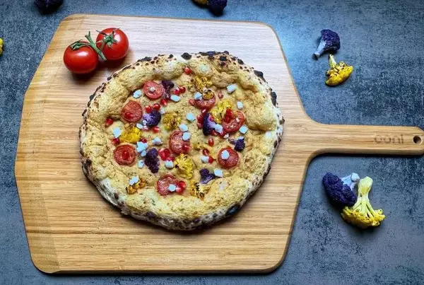 Vegane Pizza Blumenkohl Cherrytomaten Hummus und vegane Feta
