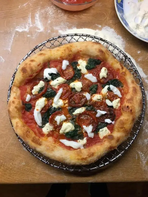 Pizza with spinach, marinated cherry tomatoes and ricotta cheese