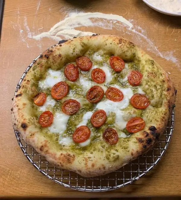 Pizza with Pesto Genovese, buffalo mozzarella and marinated cherry tomatoes